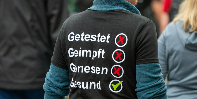 "Getestet, Geimpft, Genesen, Gesund" steht auf dem Shirt eines Demonstranten der aus Protest gegen die Coronapolitik.