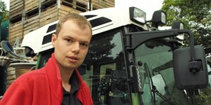 Der junge Obstbauer Niklas Eckhoff neben einem Traktor