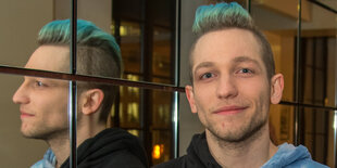 Der Youtuber Rezo lächelt und hat blaue Haare