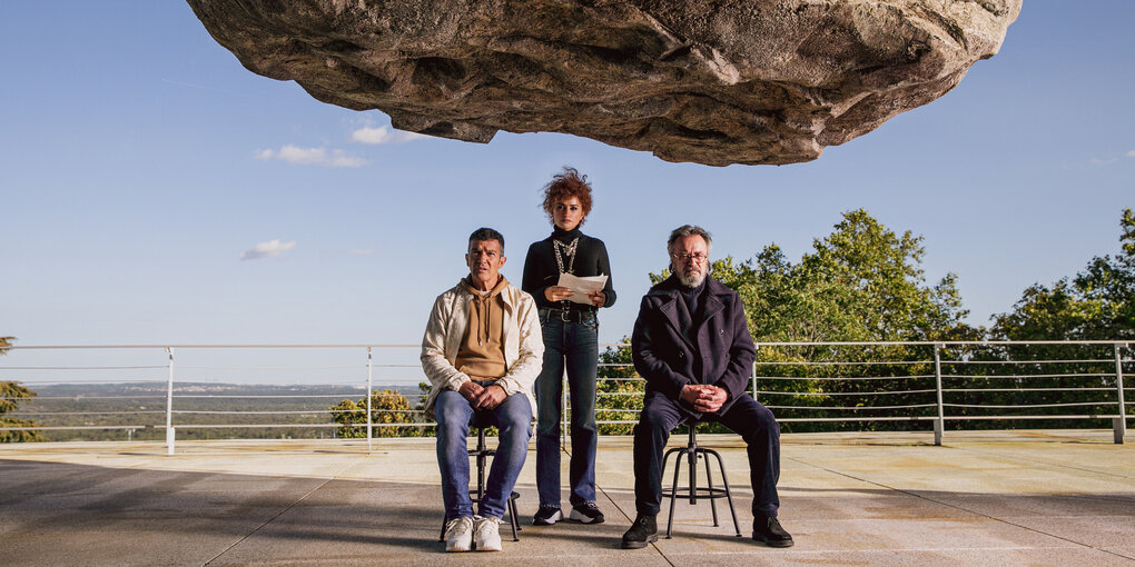 Antonio Banderas, Penélope Cruz und Oscar Martínez stehen unter einem schwebenden Felsen