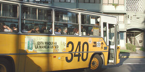 Ein gelber Bus fährt durch die Straßen von Santiago de Chile.
