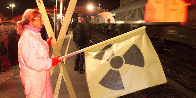 Frau mit Flagge mit Radioaktivitätssymbol