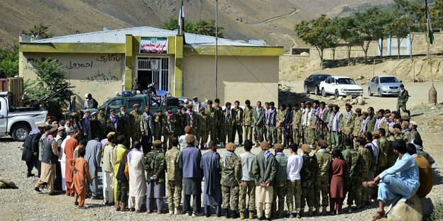 Milizionäre stehen vor einem Regierungsgebäude im Kreis