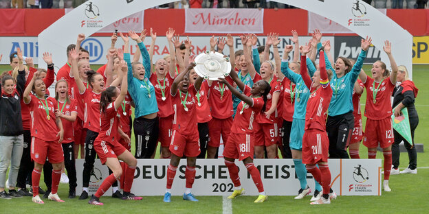 Die Spielerinnen und das Team vom FC Bayern München jubeln nach Spielende über den Sieg und über die Deutsche Meisterschaft mit der Meisterschale.