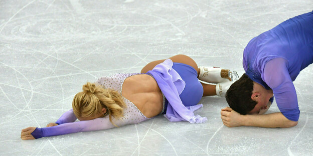 Eiskunstläuferin Aljona Savchenko liegt auf dem Eis, neben ihr Ex-Partner Bruno Massot.