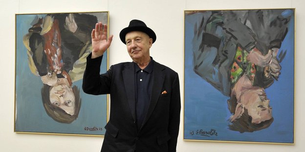 Der Maler und Bildhauer Baselitz im Albertinum in Dresden 2010, winkend posiert er vor zwei Gemälden.