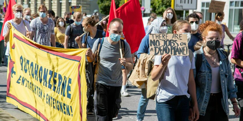 Eine Gruppe Menschen demonstriert mit Fahnen und Plakaten