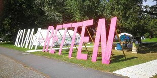 "Klima retten" steht in großen Lettern vor dem Klimaprotestcamp.