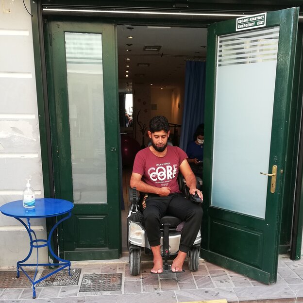 Khaled Alafaat kommt mit dem Rollstuhl aus einer Tür