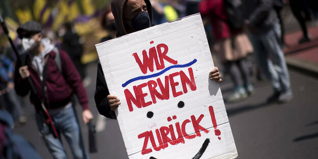 Auf einer Demonstration gegen steigende Mieten im Mai hält ein Demonstrant ein Schild mit der Aufschrift "Wir nerven zurück" hoch.