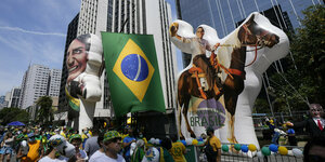 Eine Menschenmenge zeigt ein Bild mit Brasiliens Präsidenten Bolsonaro als stolzem Reiter