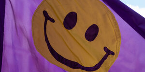 Lachendes gelbes Smiley auf einer lilafarbenen Fahne