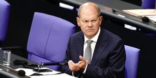 Olaf Scholz sitzt im deutschen Bundestag und klatscht