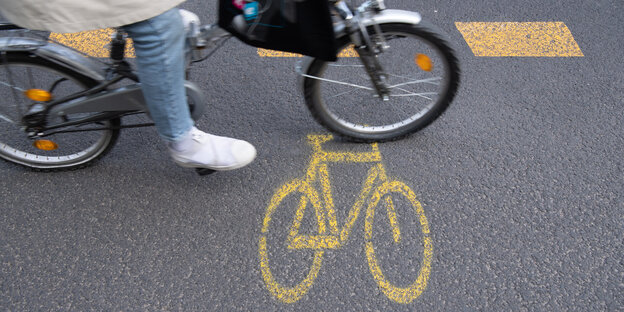 Ein Fahrradsymbol und eine gestrichelte Linie auf dem Asphalt markieren einen provisorischen Radweg.