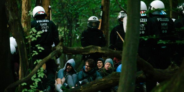 Polizisten umzingeln Demonstranten im Wald