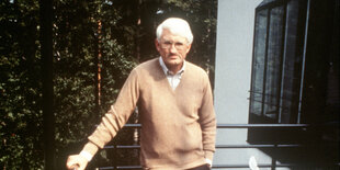 Jürgen Habermas steht an einem Geländer, hinter ihm Wald