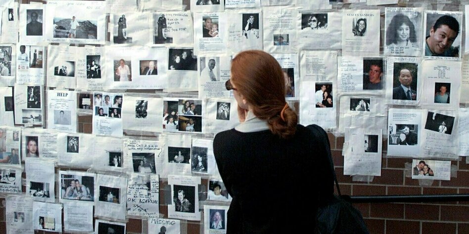 Eine Frau vor einer Wand von Vermisstenplakaten