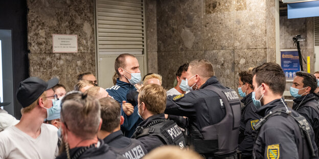 Eine Gruppe Menschen wird an der Rolltreppe im Zwischengeschoss des Odeonsplatzes von der Polizei eingekesselt.