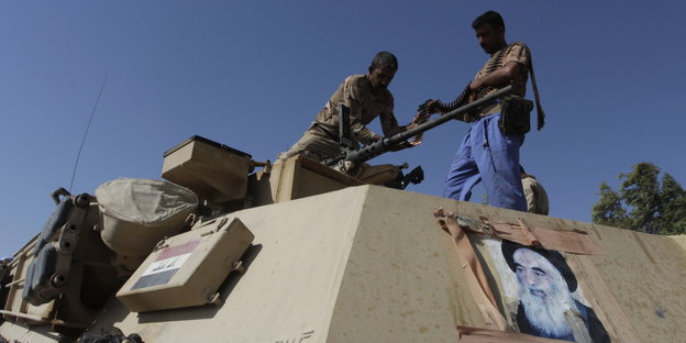 Kämpfer der Badr-Miliz befüllen einen Panzer