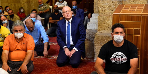 Najib Mikati zwischen weiteren Gläubigen - er kniet auf dem Teppich einer Moschee