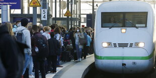 Voller Bahnsteig am Berliner Hauptbahnhof. Ein ICE fährt ein.