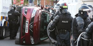 Polizei und umgekipptes Auto