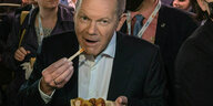 SPD-Kanzlerkandidat Olaf Scholz isst eine Currywurst nach dem Triell von ARD und ZDF