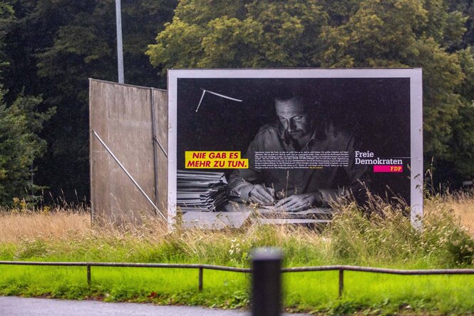 Christian Lindner auf einem Wahlplakat beim Schreiben mit der Hand