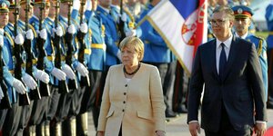 Angela Merkel und der serbische Präsident gehen an salutierenden Soldaten vorbei
