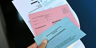 Wahlschein, Stimmzettel in der Hand