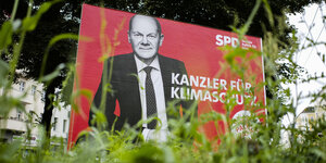 Wahlplakat von Olaf Scholz mit Grünpflanzen
