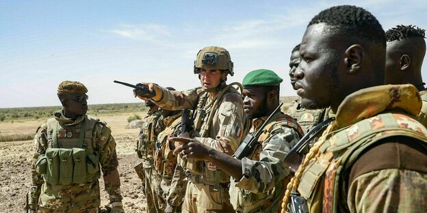 Soldaten in Tarnfleck patrouillieren in der Wüste der Sahelzone