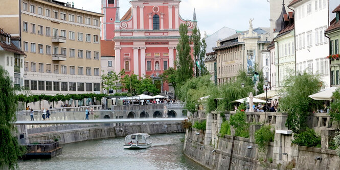 Am rechten und linken Ufer verläuft die Flaniermeile mit Dutzenden Kneipen und Restaurants. Im Hintergrund die Mariä-Verkündigung-Kirche aus dem 17. Jahrhundert.