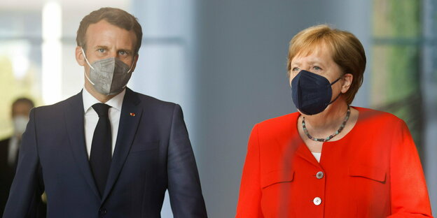 Emmanuel macron und Angela Merkel gehen nebeneinander mit Mundschutz