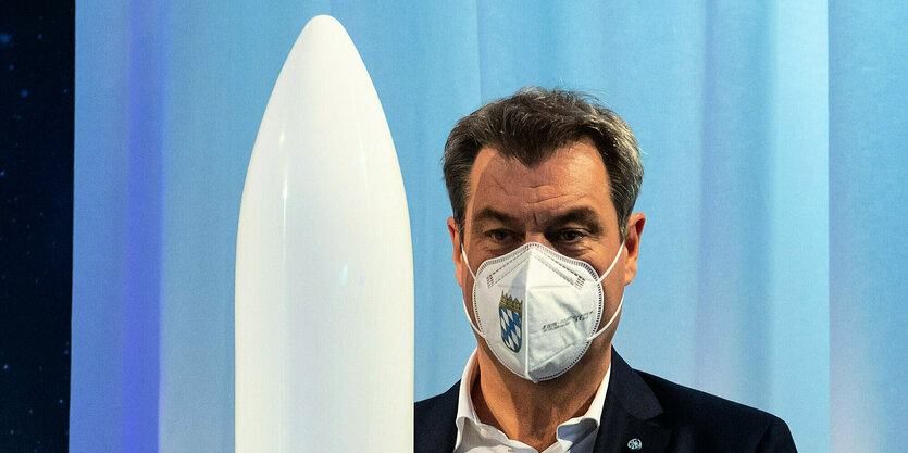 Markus Söder mit dem Modell einer Rakete