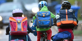 drei kinder fahren Fahrrad, mit dem Rücken zur Kamera