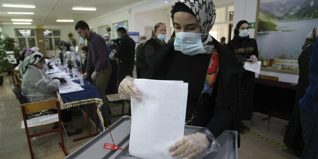 Eine Frau wirft ihren Stimmzettel ein