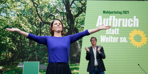 Baerbock breitet die Arme aus, im Hintergrund steht Michael Kellner