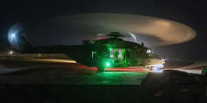 Hubschrauber steht im fahlen grünen Nachtlicht