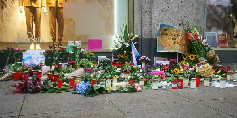 Blumen und Kerzen wurden vor dem Kaufhaus niedergelegt. Auf einem Schild steht "No Transphobia No Racism".