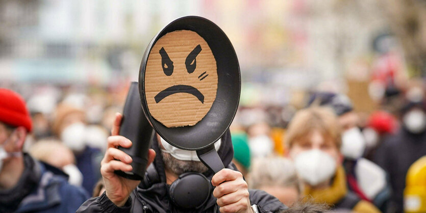 Demonstrationszug ein Mann macht mit einer Bratpfanne Krach