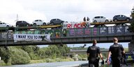 Ein Autozug wird auf einer Brücke von Umweltschutzaktivisten blockiert