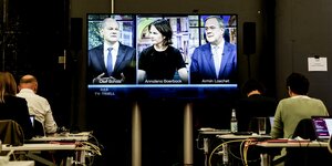 Journalisten verfolgen auf einer Leinwand das Fernseh-Triell von Annalena Baerbock, Armin Laschet und Olaf Scholz.