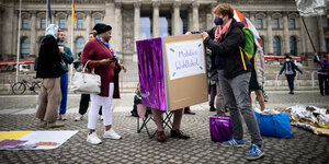 Eine Gruppe von Menschen steht vor dem Reichstag mit einem mobilien Wahllokal