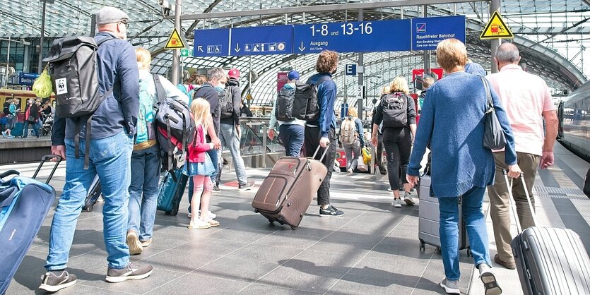 Reisende im Berliner Hauptbahnhof im Sonnenlicht