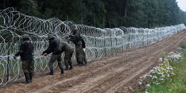 Polnische Soldaten bauen den Grenzzaun