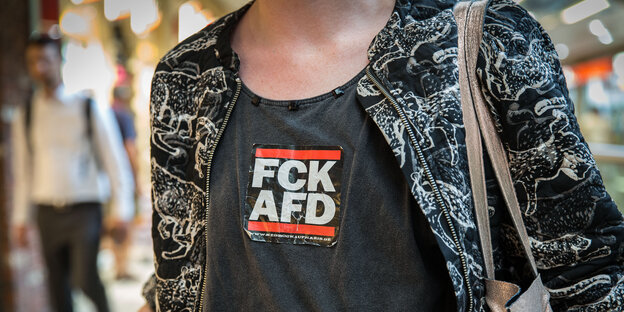 Ein Jungendlicher trägt ein T-Shirt mit der Aufschrift "FCK AfD"