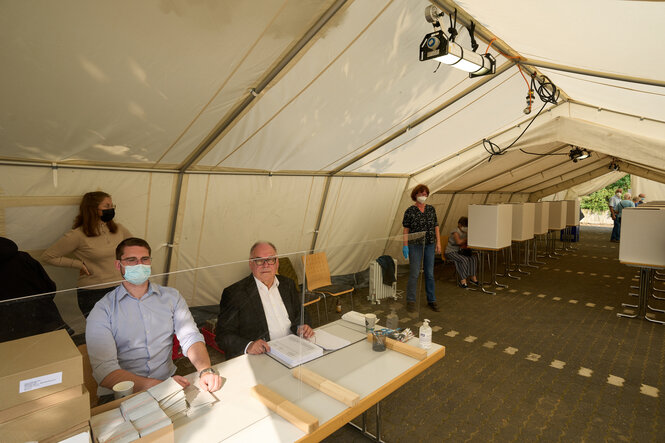 Der Wahlvorstand sitzt in einem provisorischen Wahllokal für die Bundestagswahl 2021 in einem Zelt in Ahrweiler.