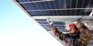 Ein Mann verschraubt Solarzellen