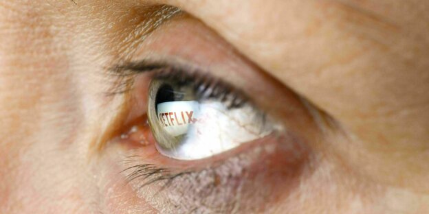 In der Nahaufnahme eines Auges spiegelt sich das Netflix Logo wider